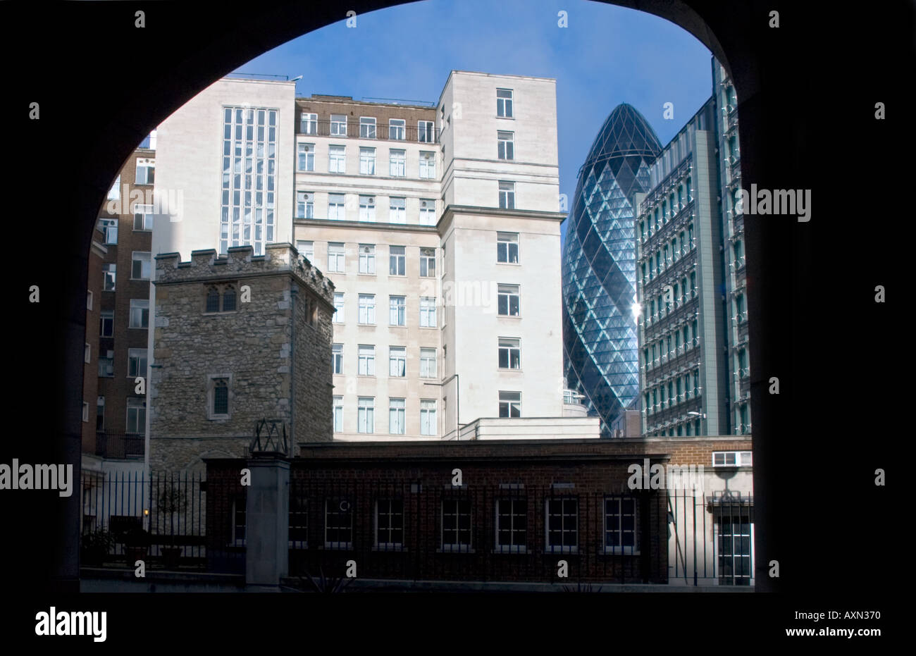 Swiss Re building or the glass gherkin In front of church of St Helen s Bishopgate Stock Photo