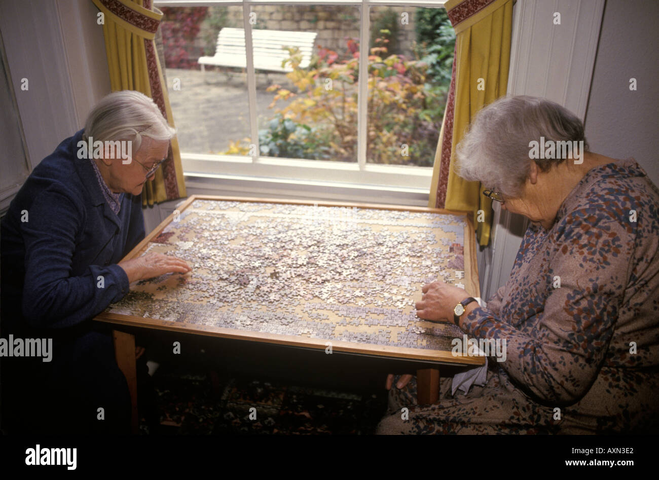 Care Home UK, elderly older lady doing a jigsaw puzzle in her private old people retirement home. Hampshire England 1990s UK HOMER SYKES Stock Photo
