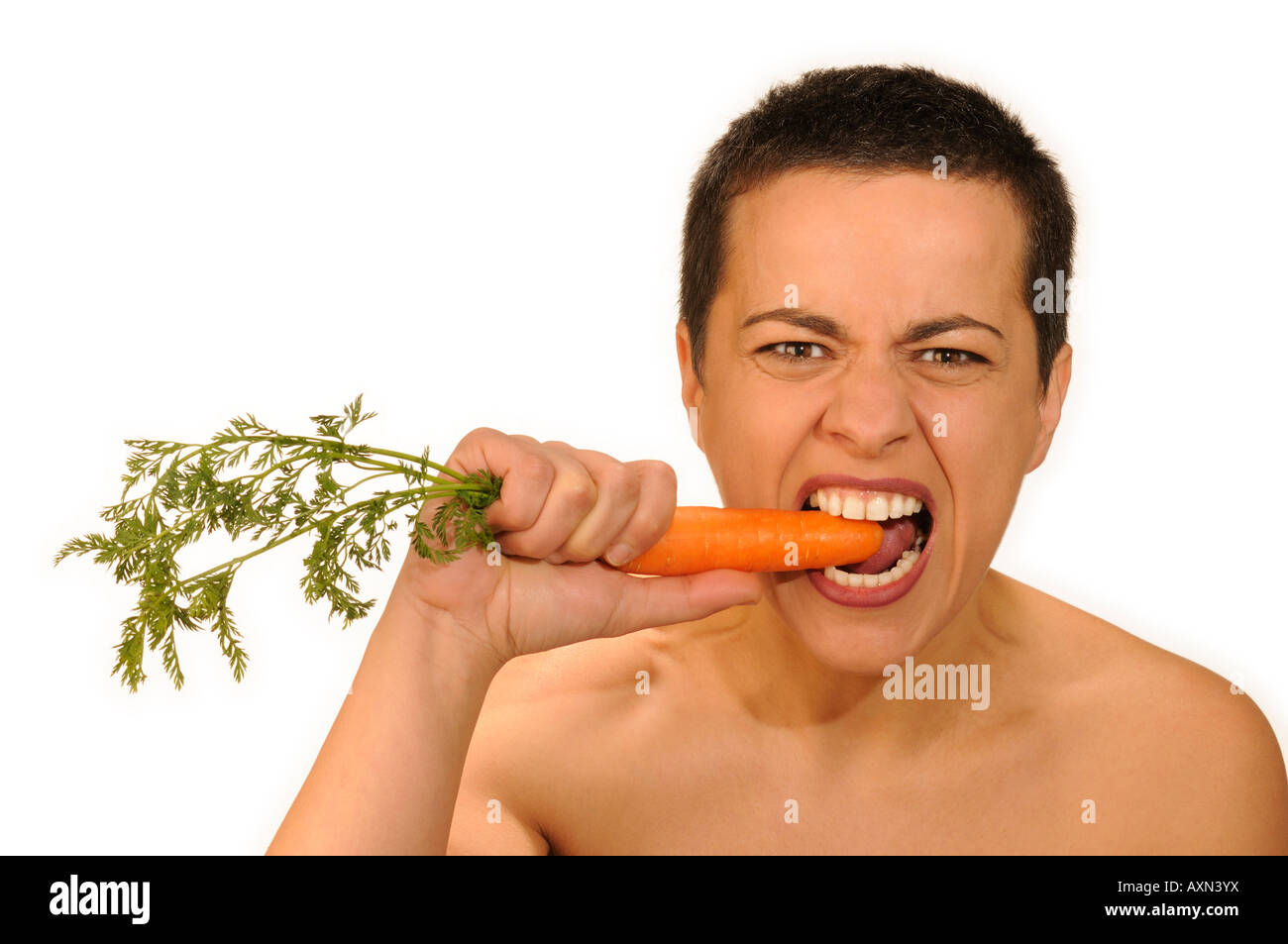 Studio portrait of woman eating a carrot Stock Photo