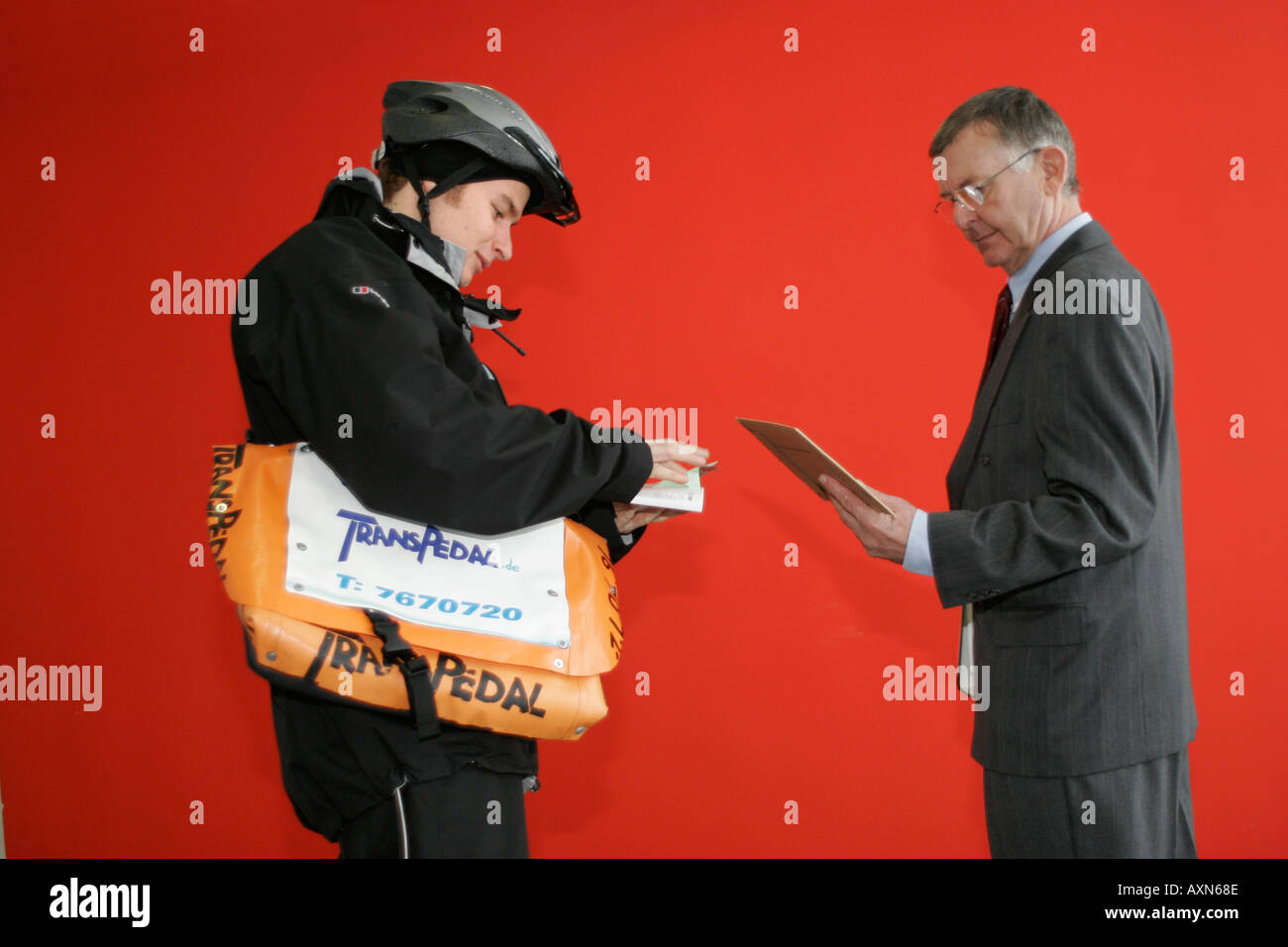 bike messenger in Munich Germany handing over letter to business man property release for bag and model Releases are available Stock Photo