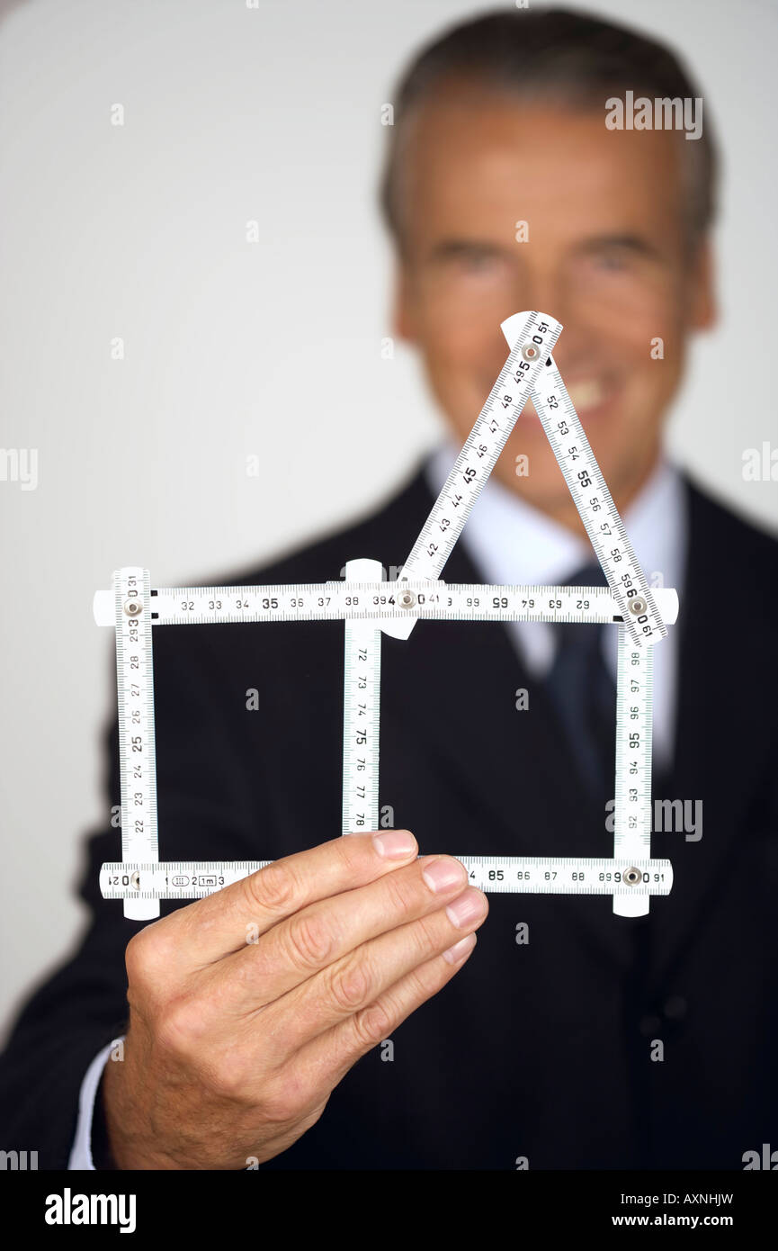 Senior businessman holding a model of a house Stock Photo - Alamy