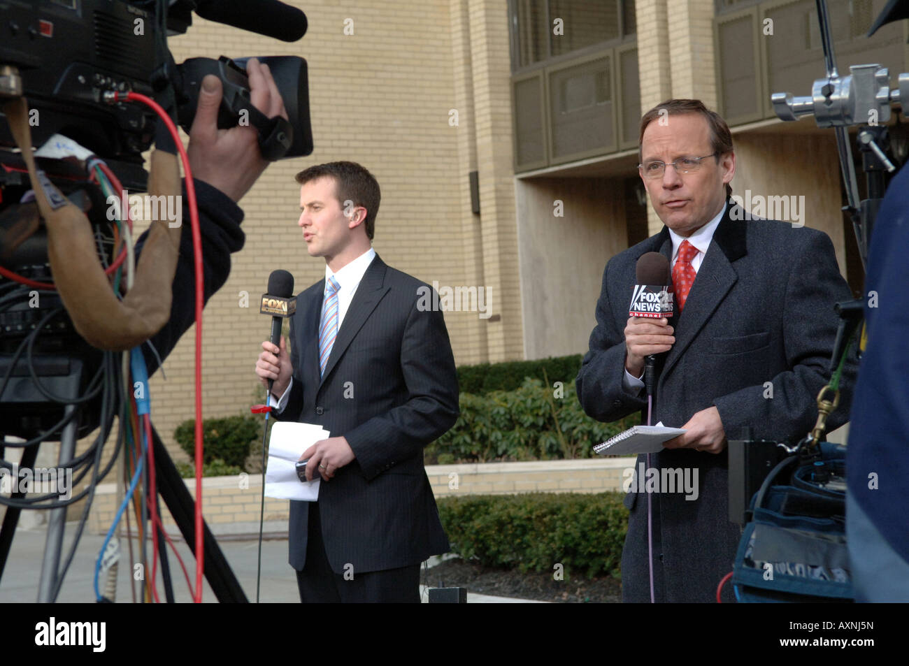 Television reporters from two different Fox News channels do simultaneous stand ups Stock Photo