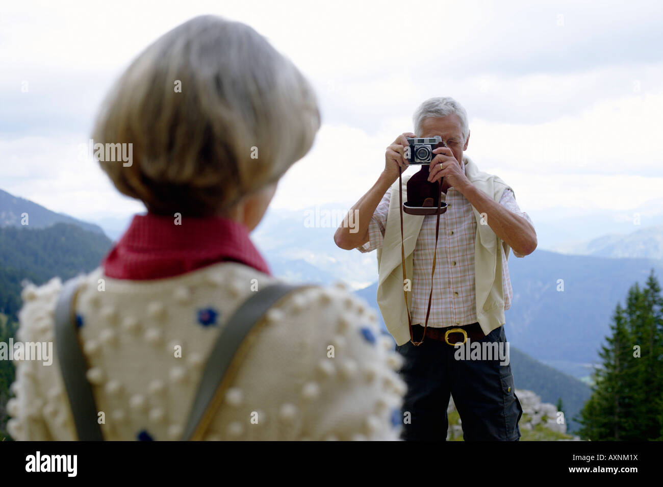 Senior adult man taking a picture of his wife in the mountains