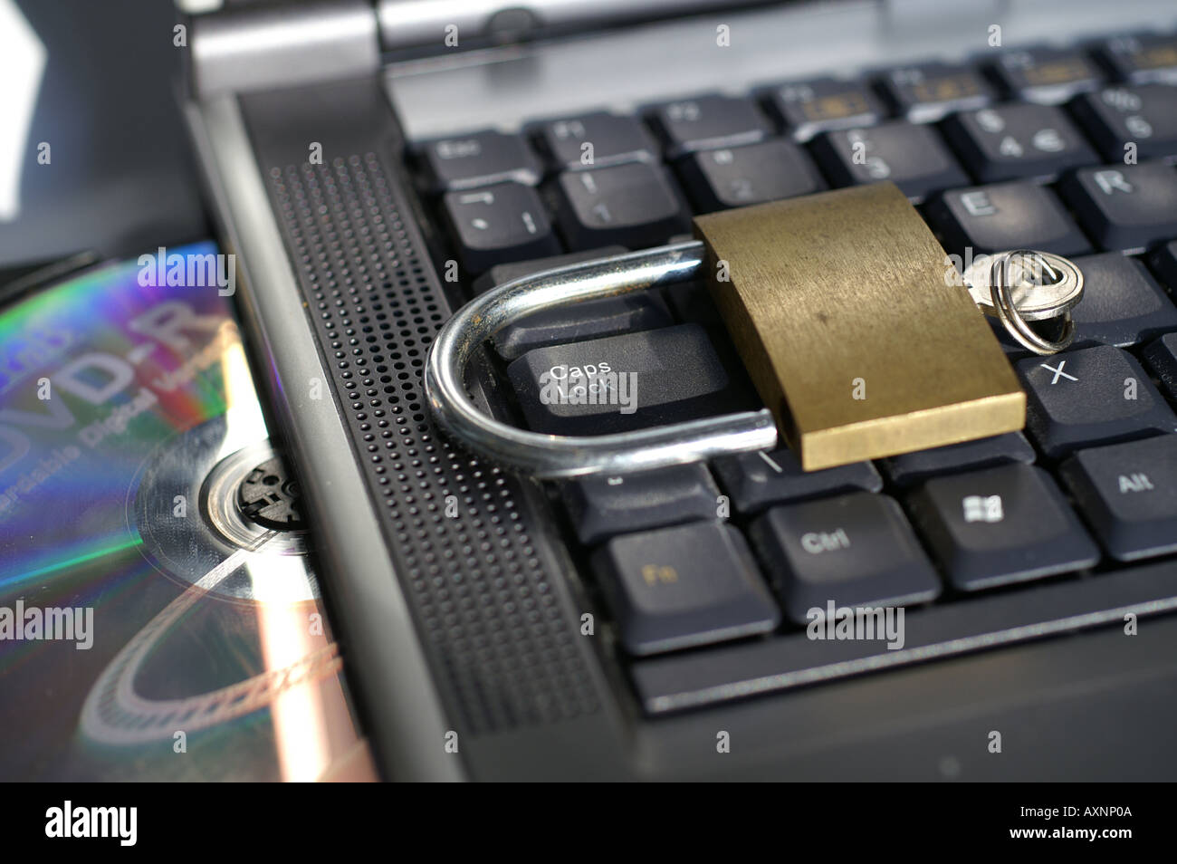 Open padlock around Caps lock key on laptop keyboard with disc Stock