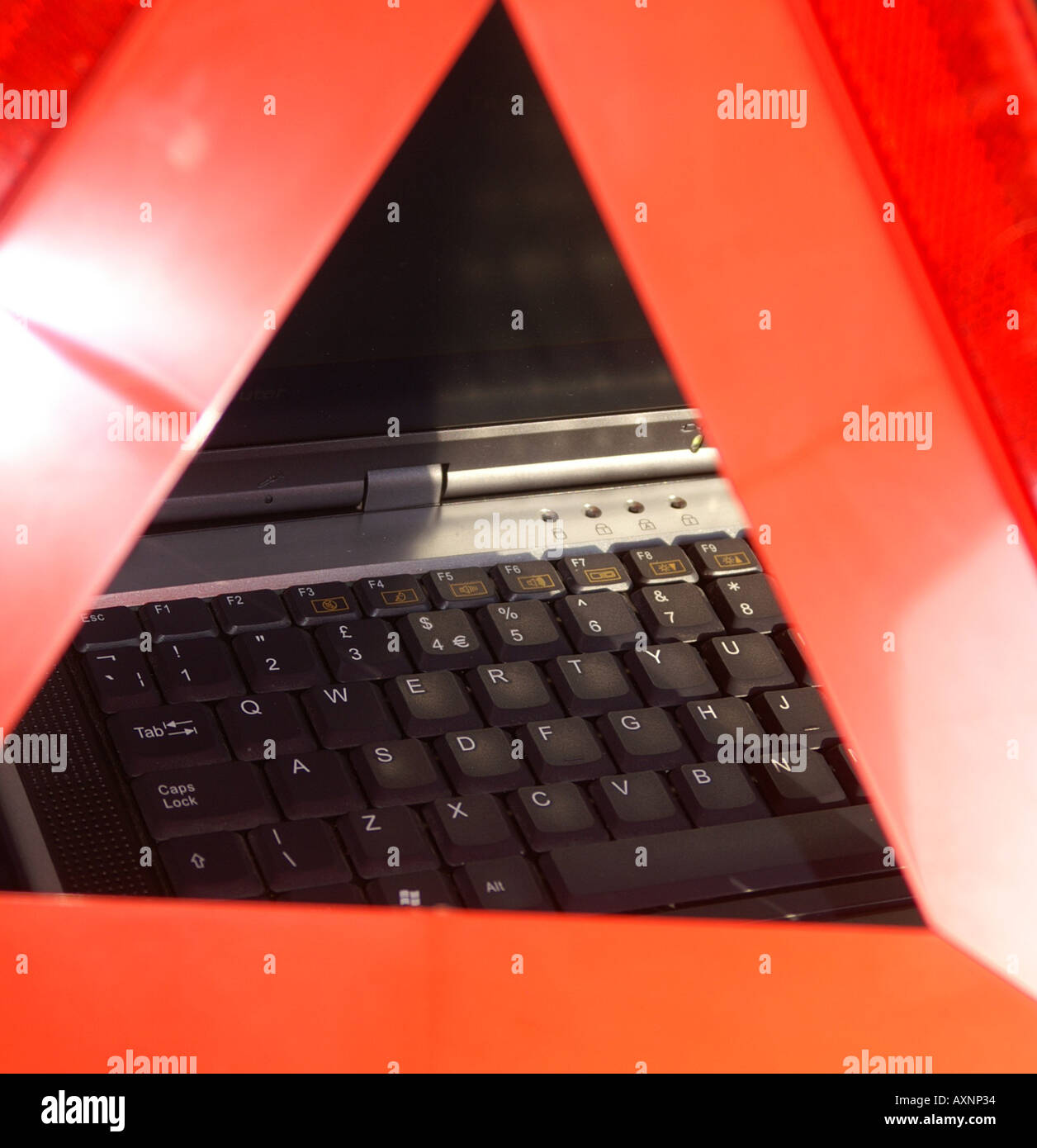 Laptop keyboard through a hazard warning triangle Stock Photo Alamy