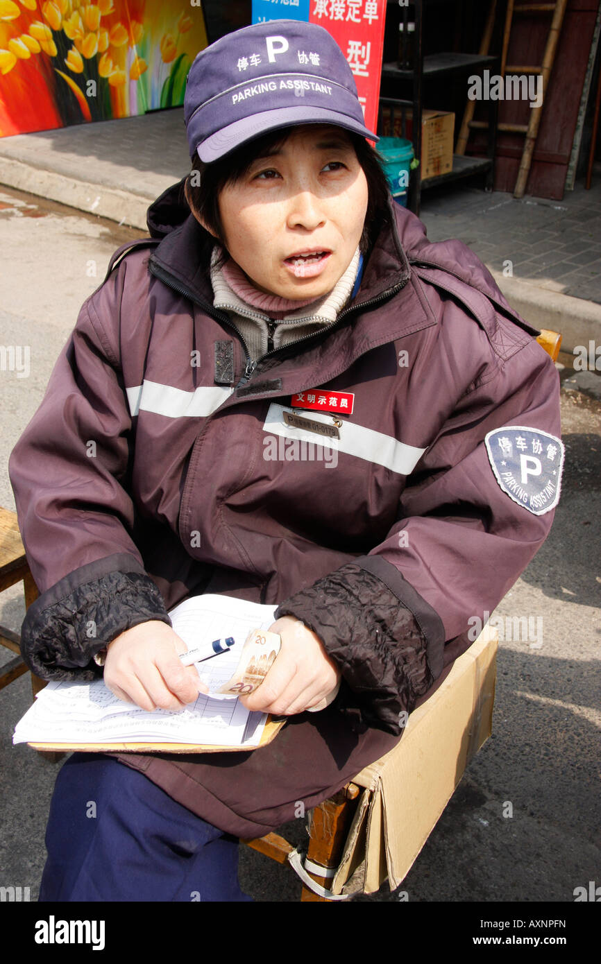 Chinese traffic warden writes a parking violation ticket in Shanghai, Cnina Stock Photo