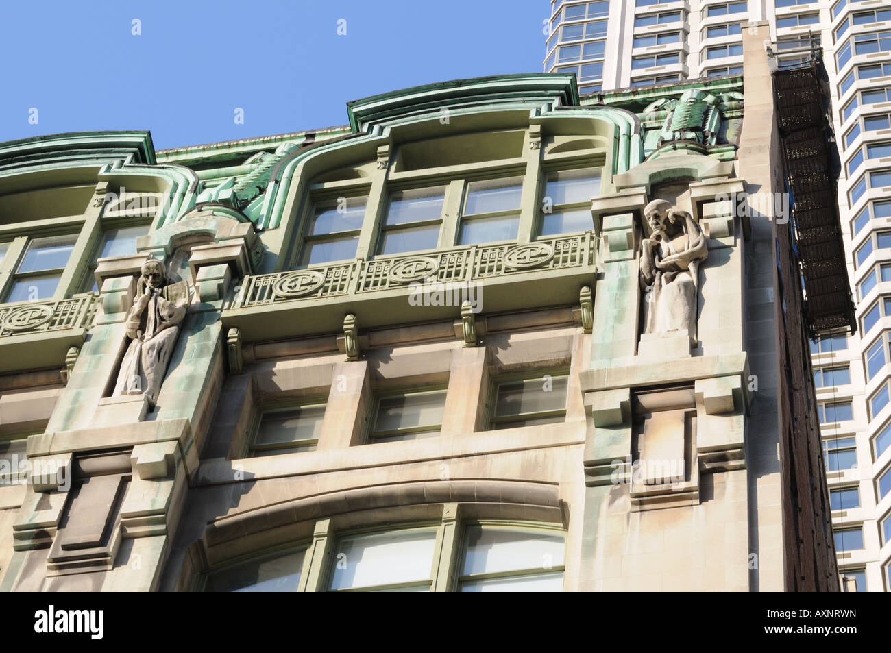 Two of four statues atop a building in Lower Manhattan that was constructed in 1906-07 for the New York Evening Post. Stock Photo