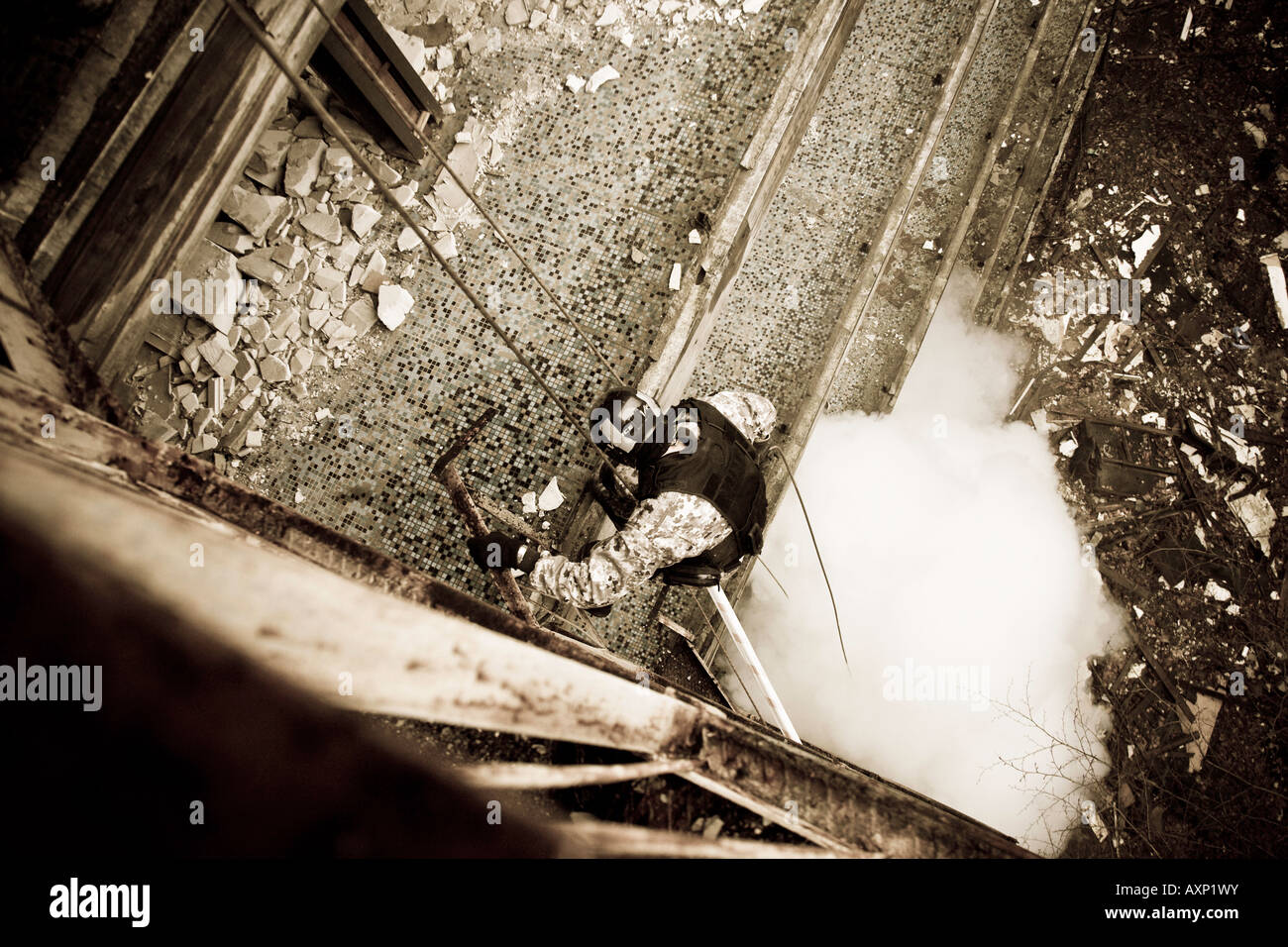 An anti-terrorist soldier is abseiling during drills. A smoke grenade was thrown down to cover the action. Stock Photo