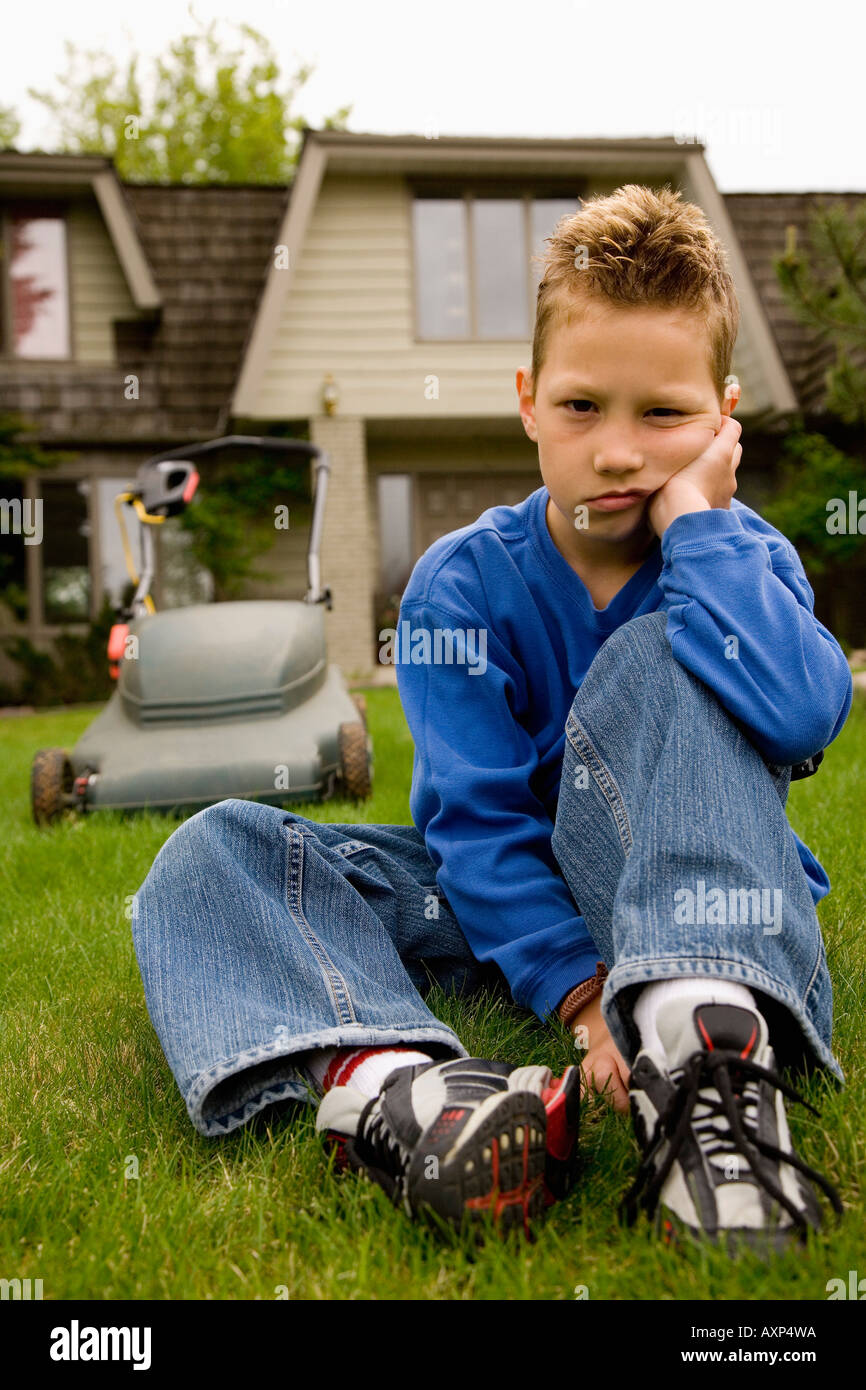 Child refusing to mow the lawn Stock Photo