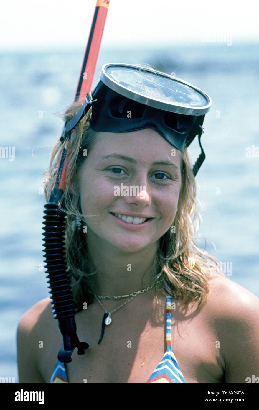 A young girl wearing a snorkel and dive mask prepares to examine a