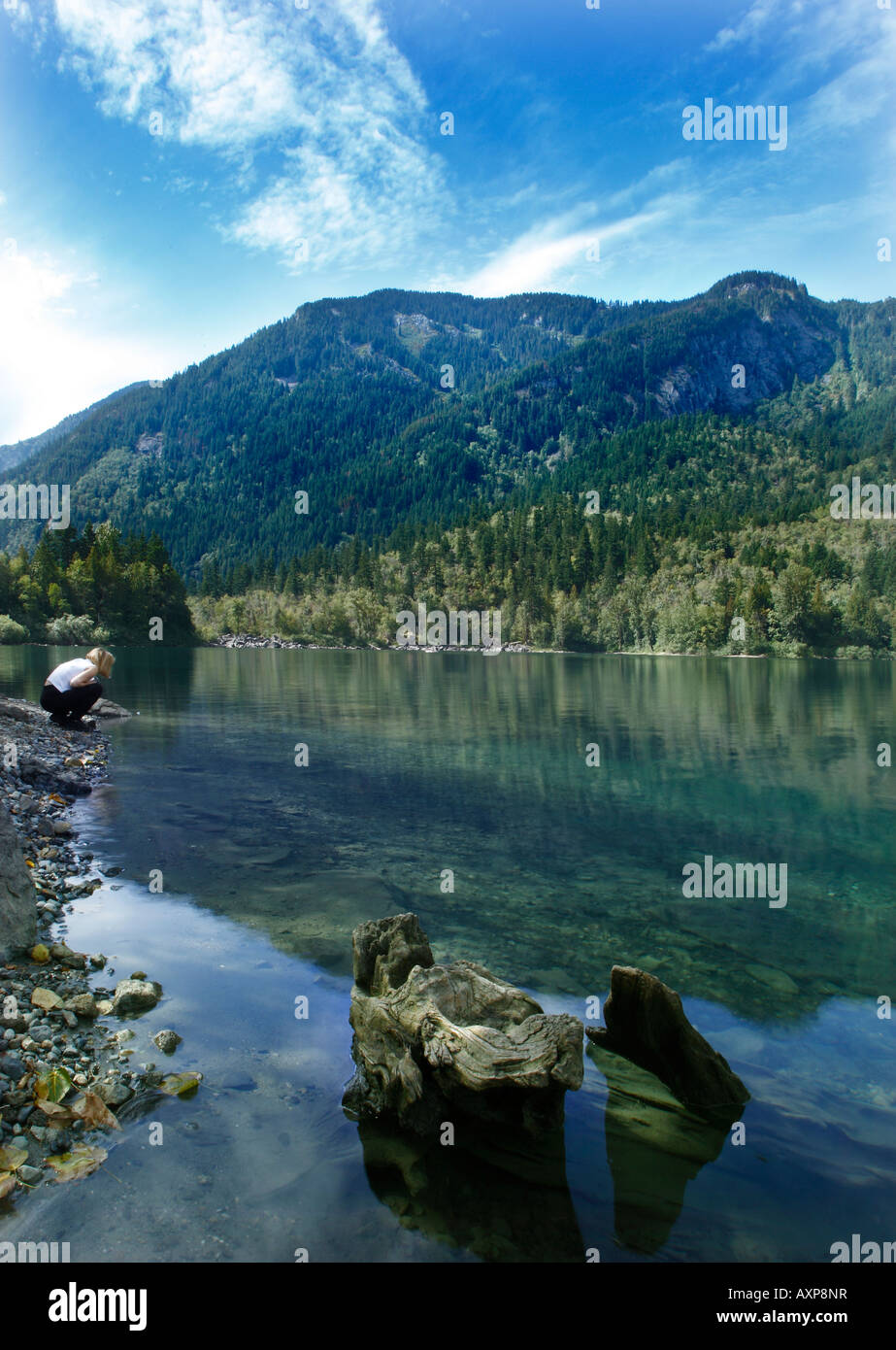 A woman watches the trout in the lake of the Schkam lake, known locally as the Lake of the Woods Stock Photo