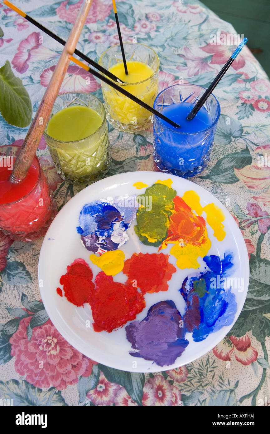 Paints, brushes, & rinse glasses on table USA Stock Photo