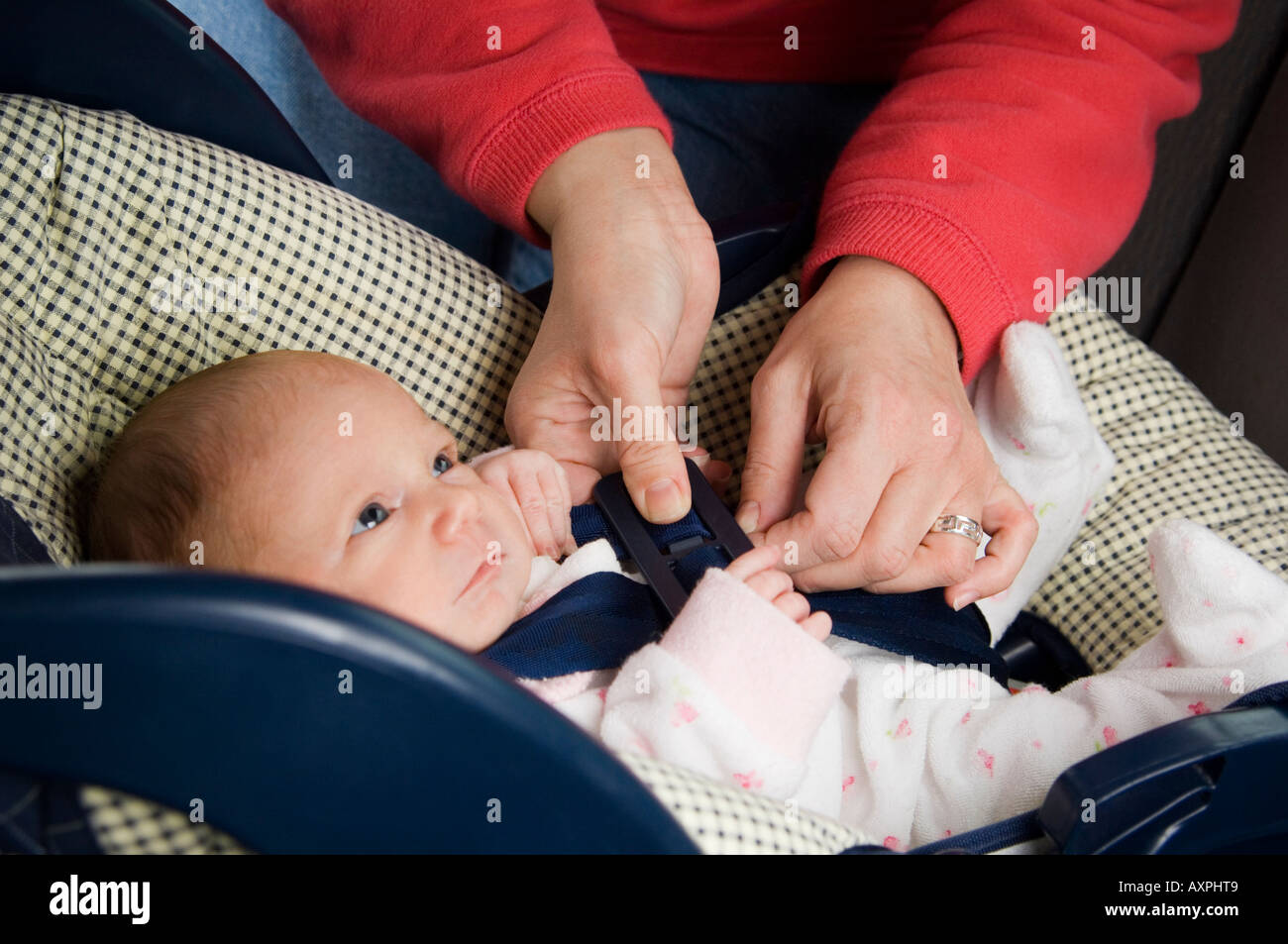 Woman strapping baby in car seat Stock Photo Alamy