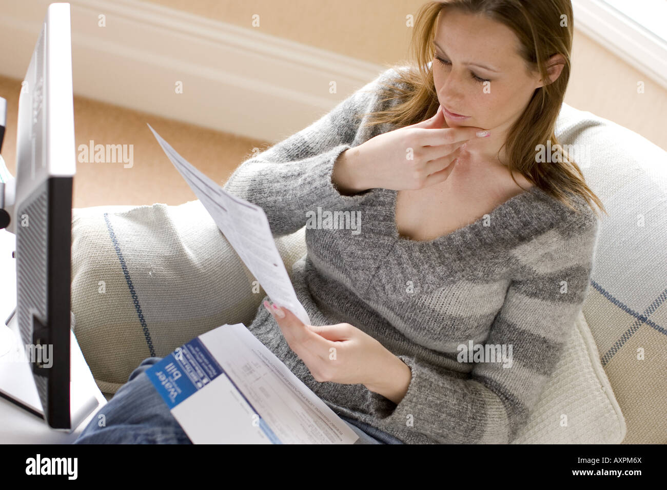 Woman looking at utility bills Stock Photo