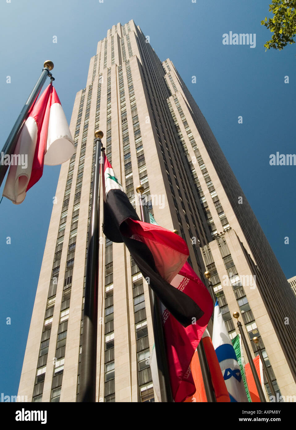 World flags fly beneath the Ge Building in the Rockefeller Plaza, New York City USA Stock Photo