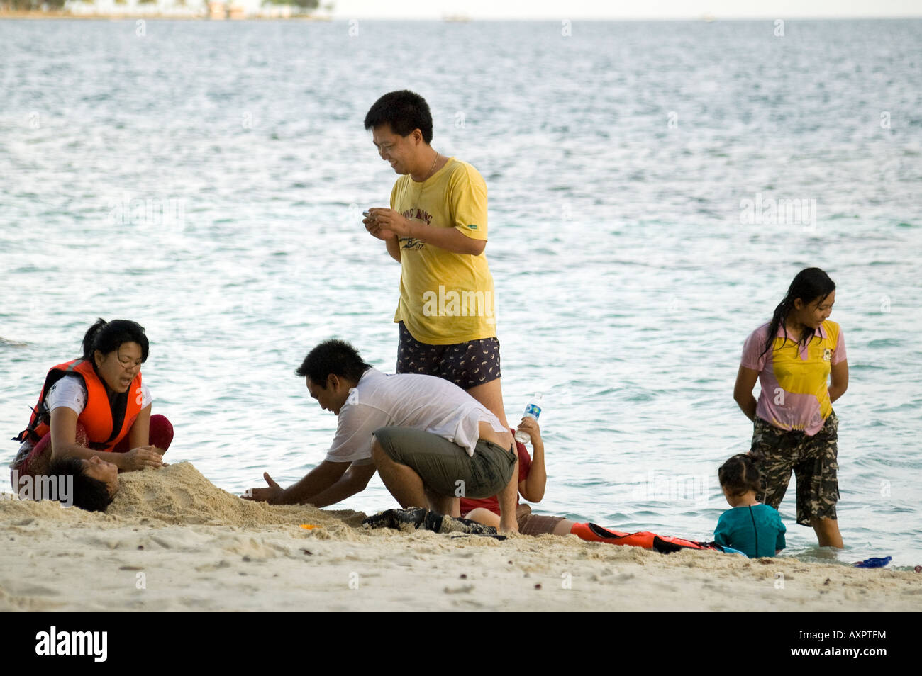 A family is having fun on the beach of Sepa Island. Stock Photo