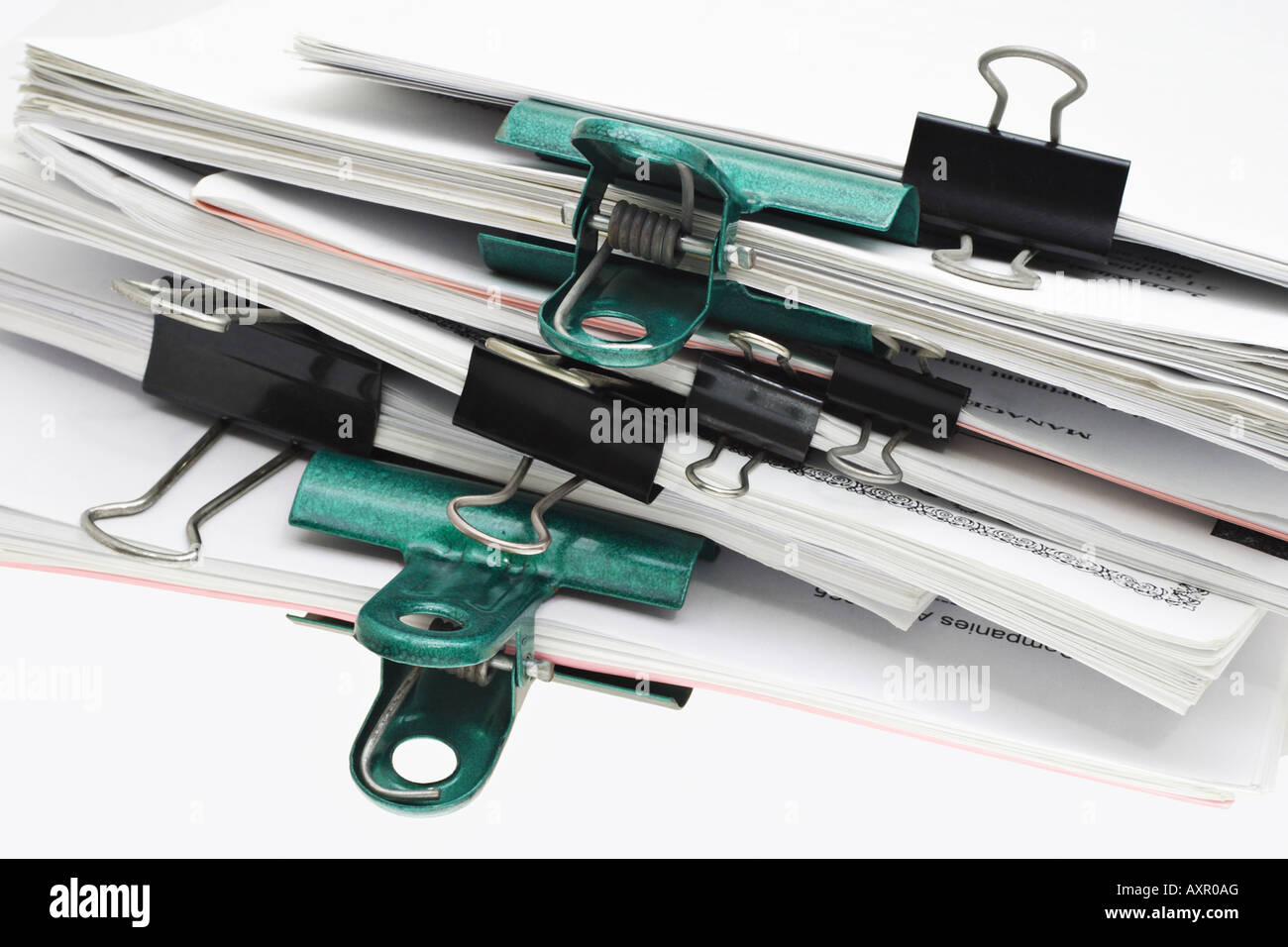 Stack of papers being held together by bulldog and crocodile clips of