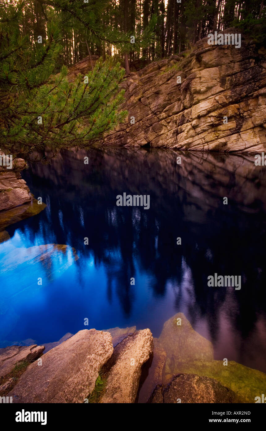 Rocks and trees reflected in water Stock Photo - Alamy