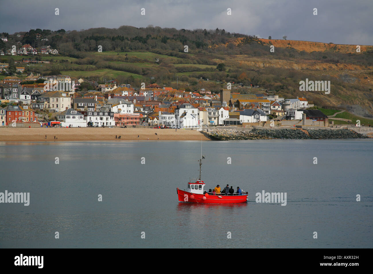 Fishing boat with fishermen returning to Lyme Regis harbour Dorset UK ...