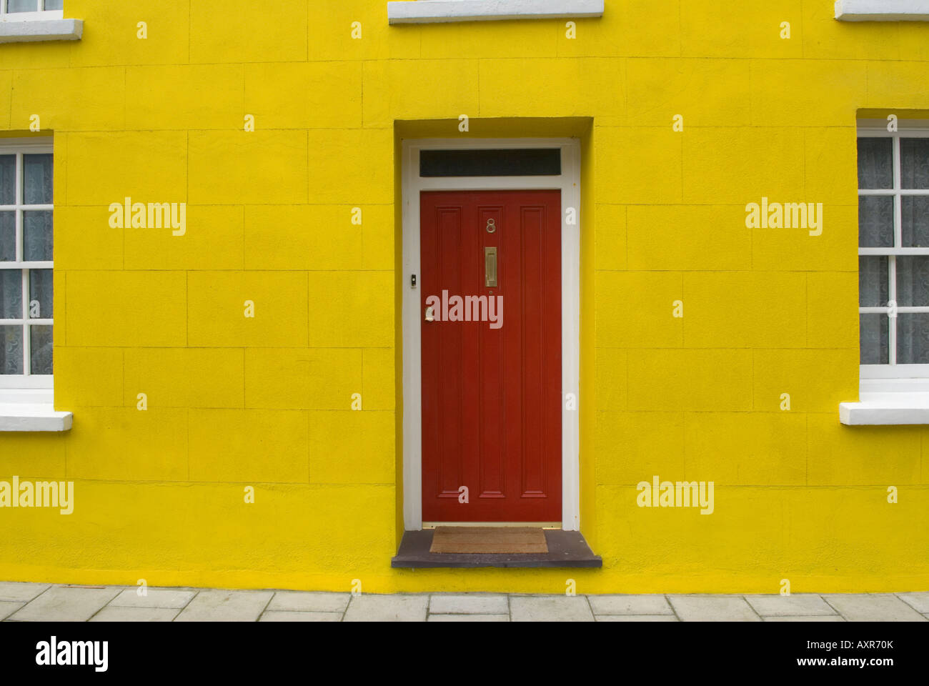 Yellow house with red door Aberaeron west Wales UK HOMERSYKES Stock Photo