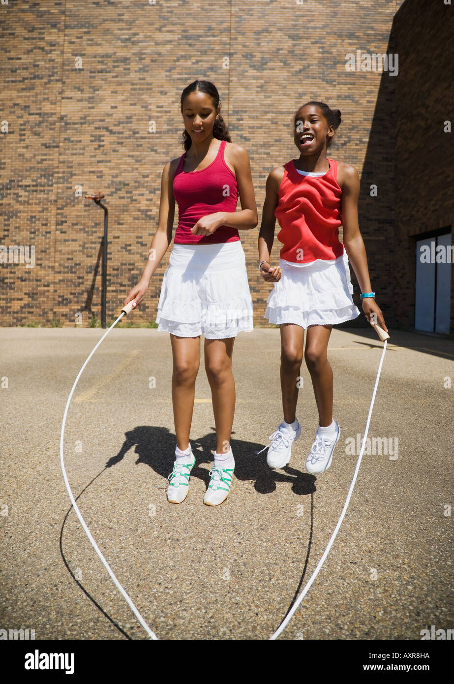 Girls jumping rope together Stock Photo Alamy