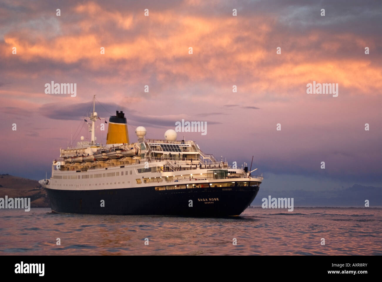 A cruise ship arrives at the entrance to Lyttelton Harbour, New Zealand, at sunrise. Stock Photo