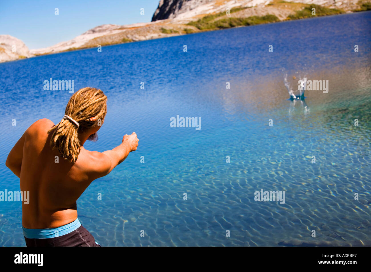 Man skipping rocks in water Stock Photo - Alamy