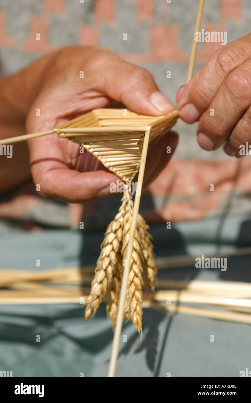 Craftsman making a corn dolly from corn Stock Photo