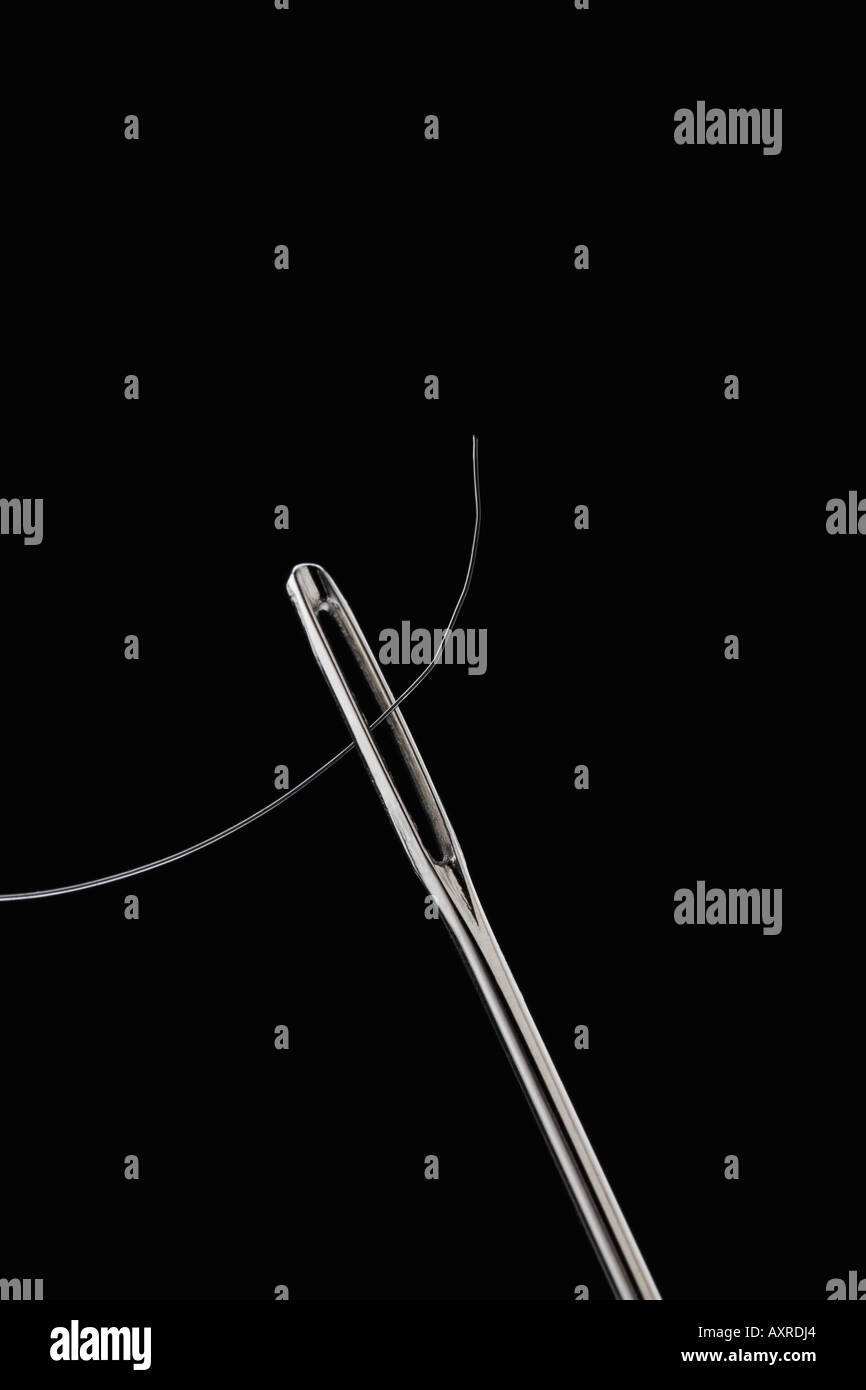Thread through eye of needle Stock Photo - Alamy