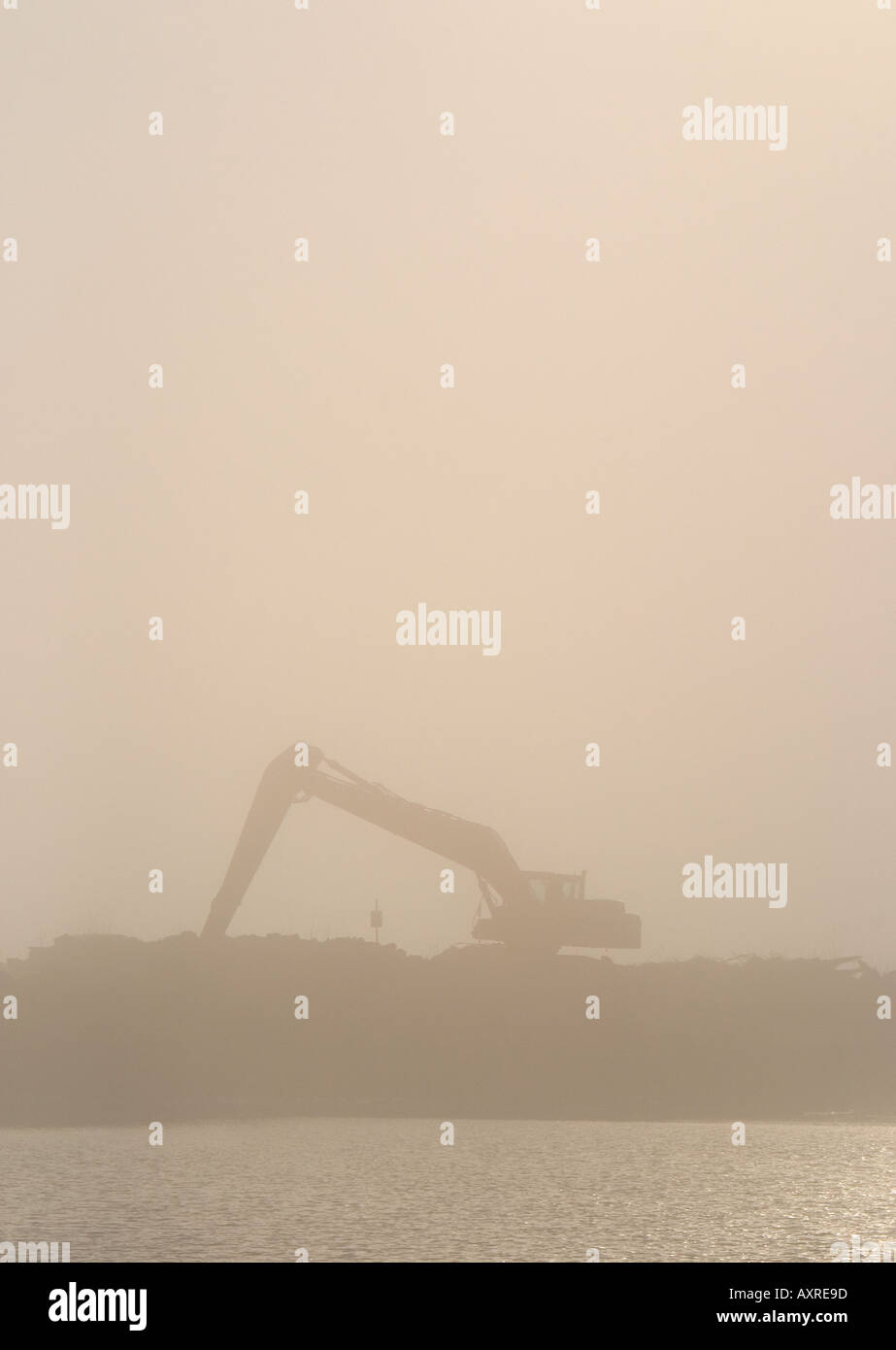 Digger silhouette in morning fog at riverbank , Finland Stock Photo