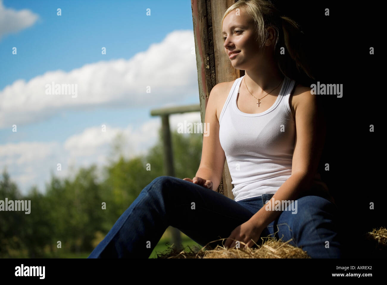 Woman sitting in a barn loft Stock Photo - Alamy