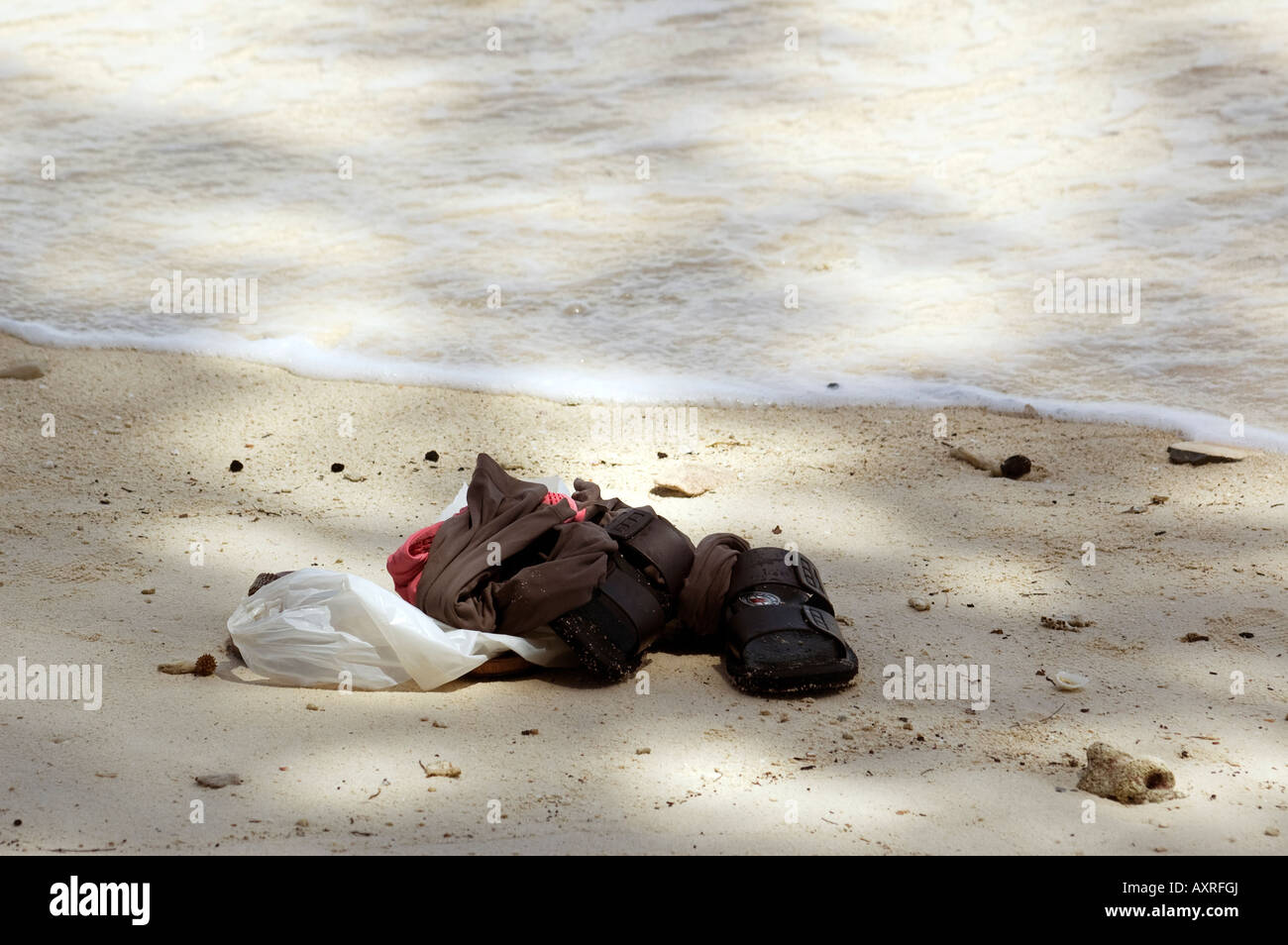 Shoes and clothes left on the beach of Sepa Island near the water Stock Photo