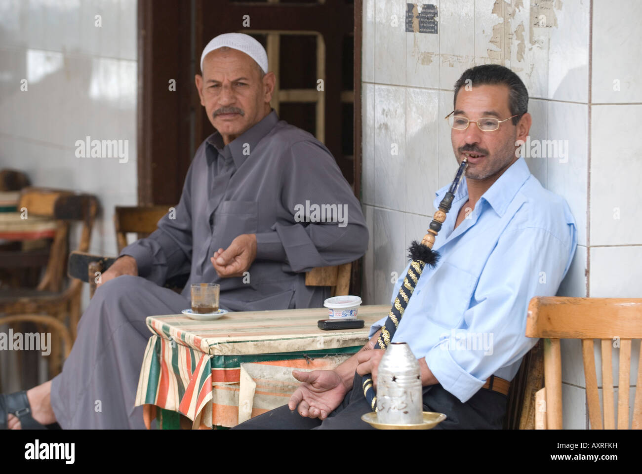Man Smoking water pipe in Ismailia Egypt coffee shop street side cafe Stock Photo
