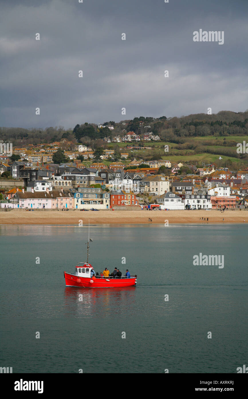 Fishing boat with fishermen returning to Lyme Regis harbour Dorset UK ...