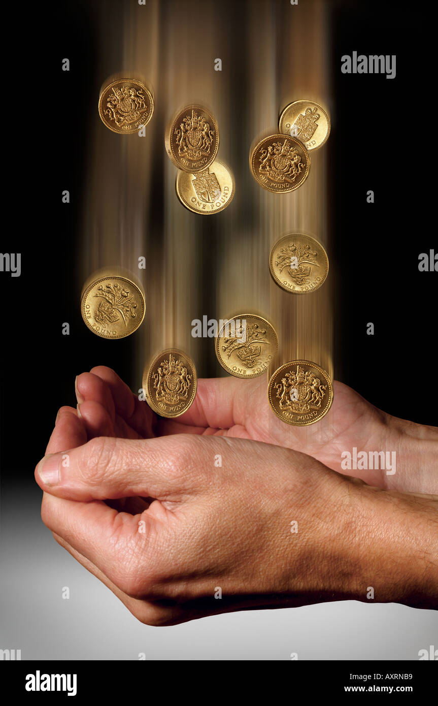 Hands catching falling Pound coins Stock Photo