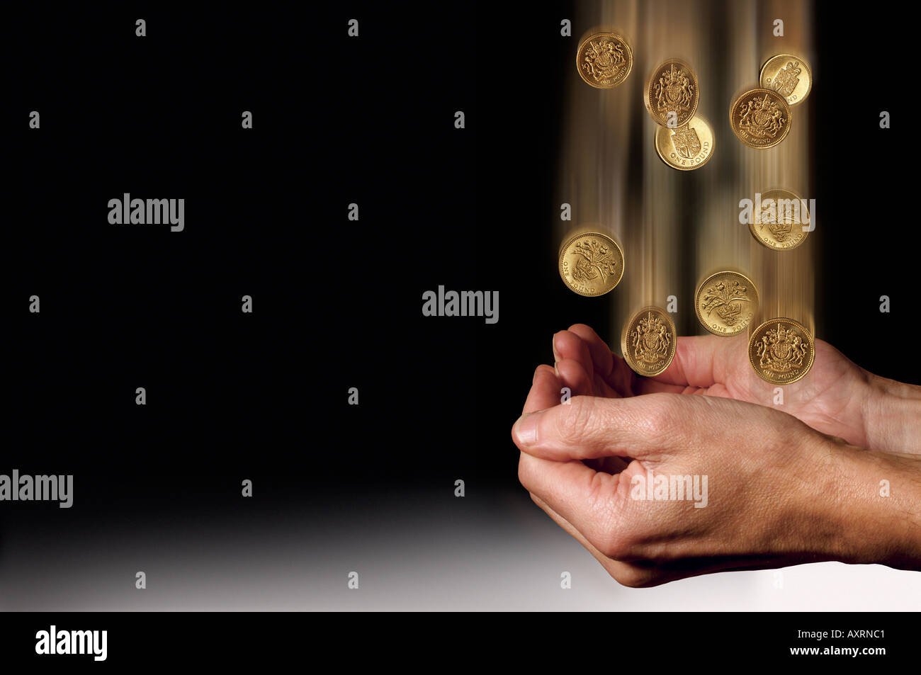 Hands catching falling Pound coins Stock Photo