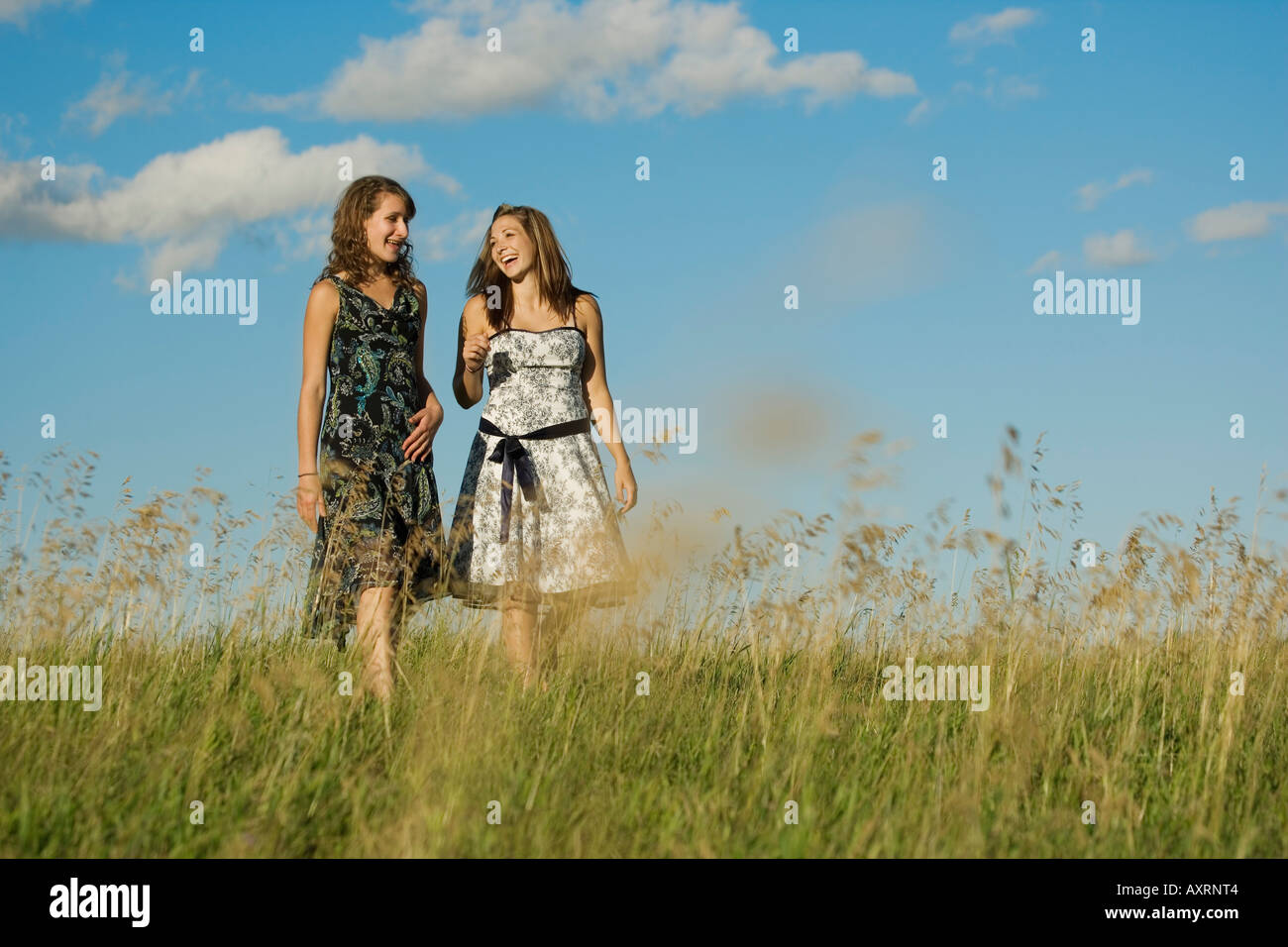 Two young women walking in field Stock Photo - Alamy