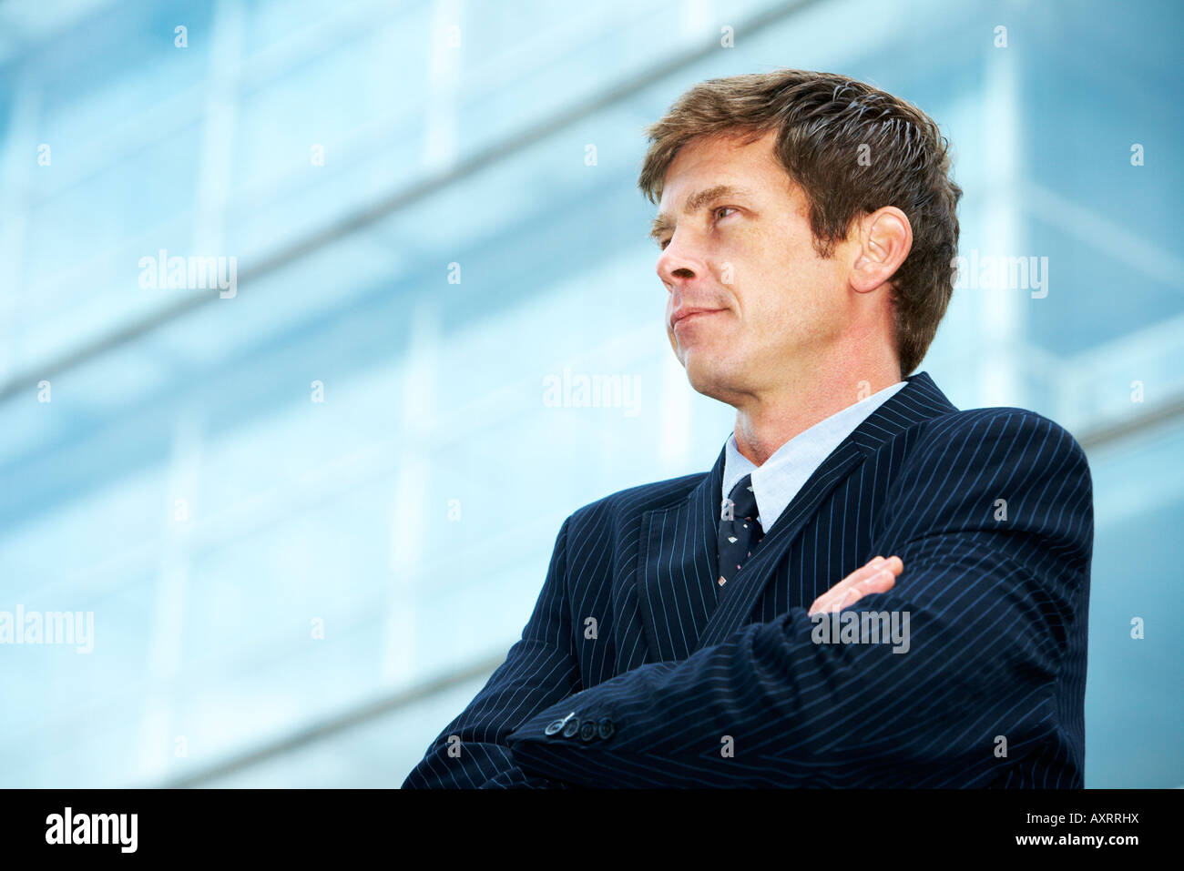 Man outside office building with arms crossed Stock Photo - Alamy