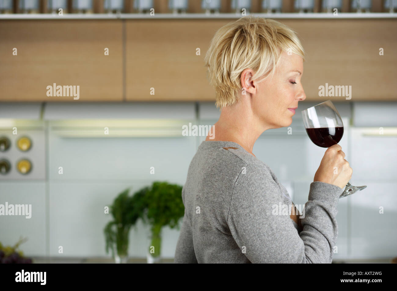 Mature woman with a glass of red wine in her hand, selective focus ...