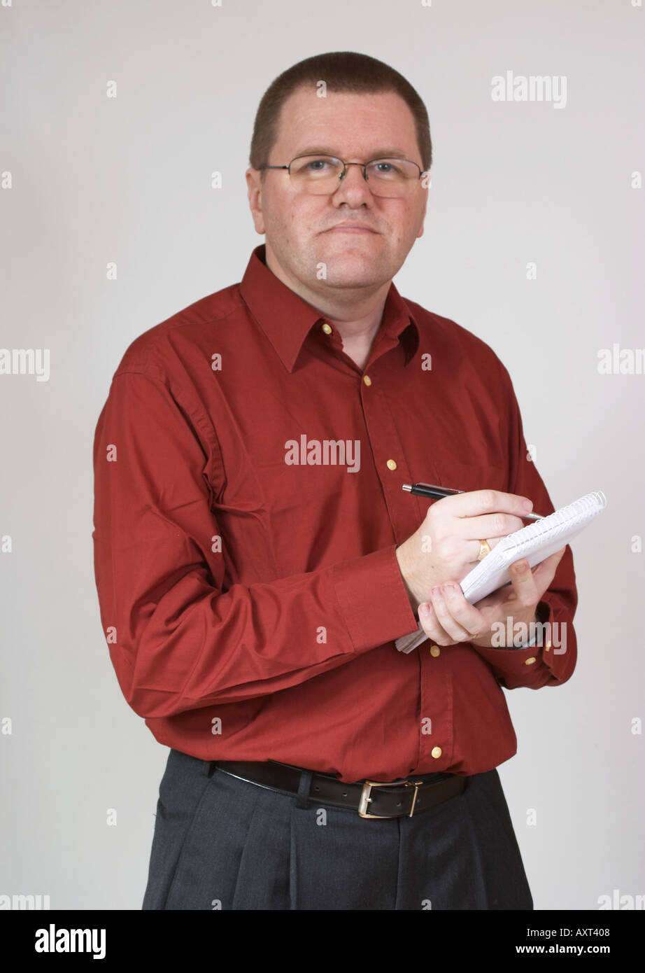 Man with notebook and pen wearing a red shirt. Stock Photo
