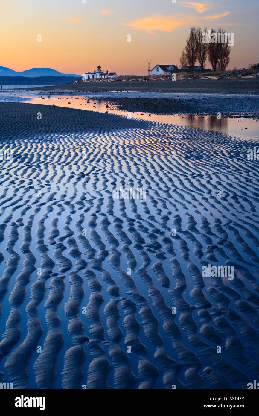 Ridges in the sand at Seattle s Discovery Park Low tide exposes a wide beach with West Point Lighthouse in the background Stock Photo