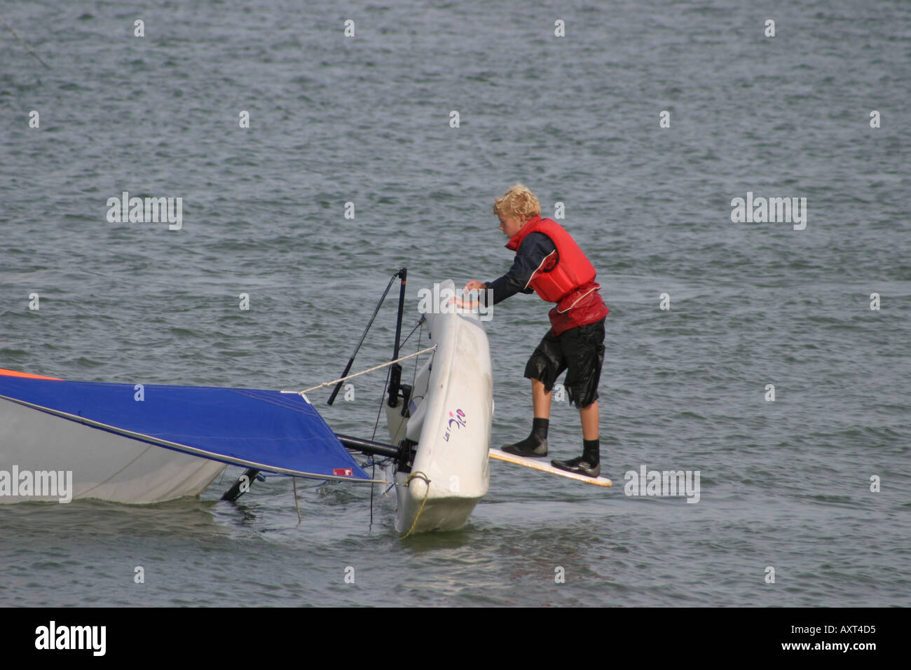 Capsized boy tries to right his boat Stock Photo - Alamy