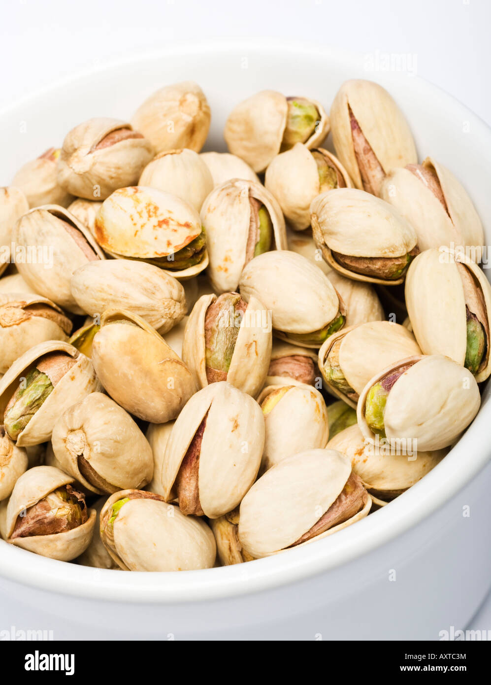 https://c8.alamy.com/comp/AXTC3M/pistachios-in-a-white-bowl-close-up-AXTC3M.jpg
