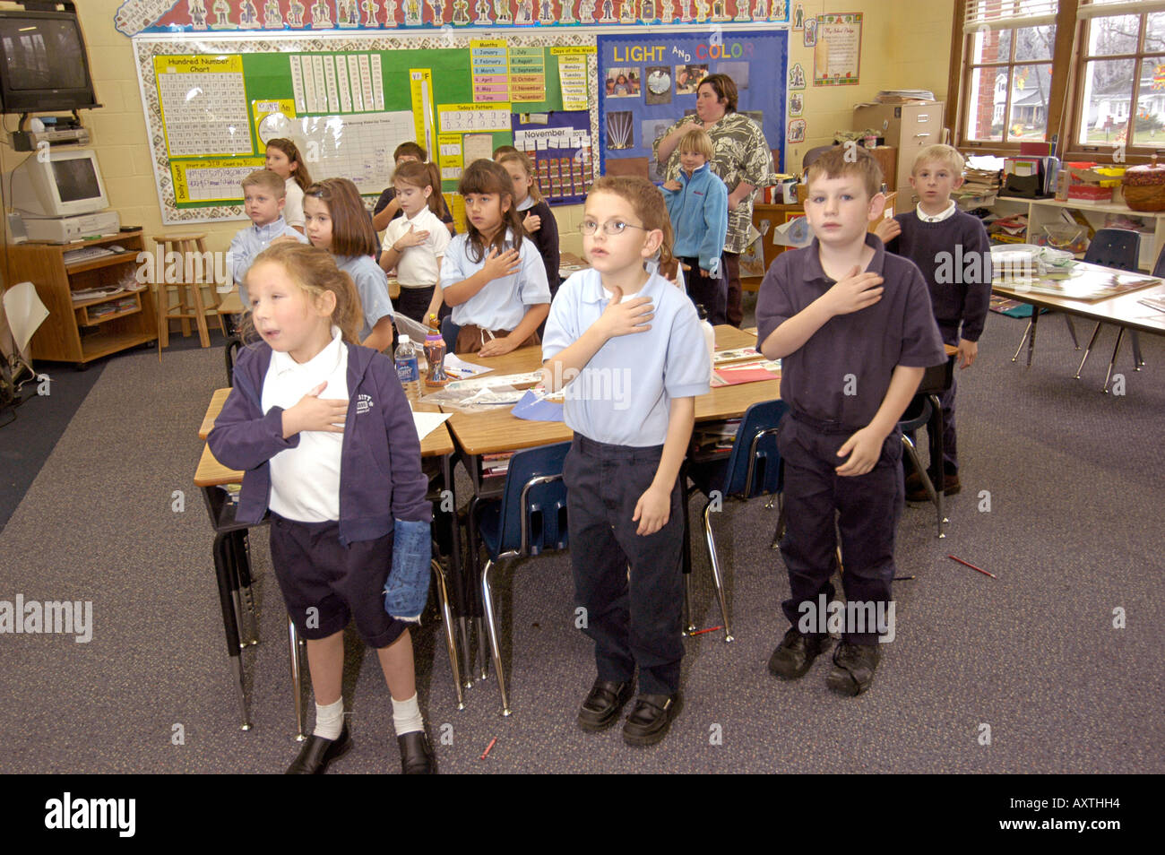 Children say pledge of allegiance to the American flag at St Marys Catholic Elementary school in St Clair Michigan MI Stock Photo