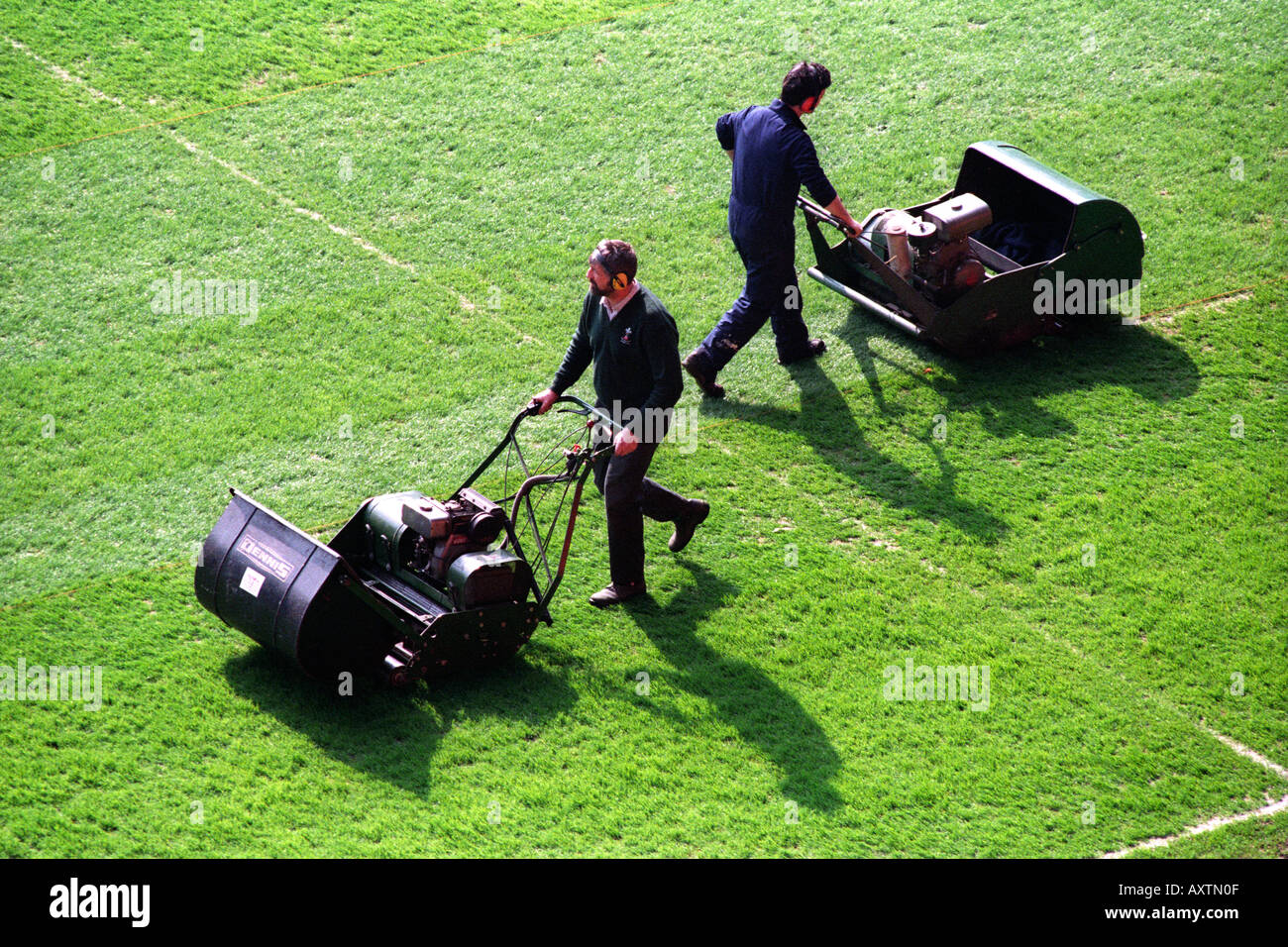 Groundsmen cutting grass on a sports pitch with mowers Stock Photo Alamy