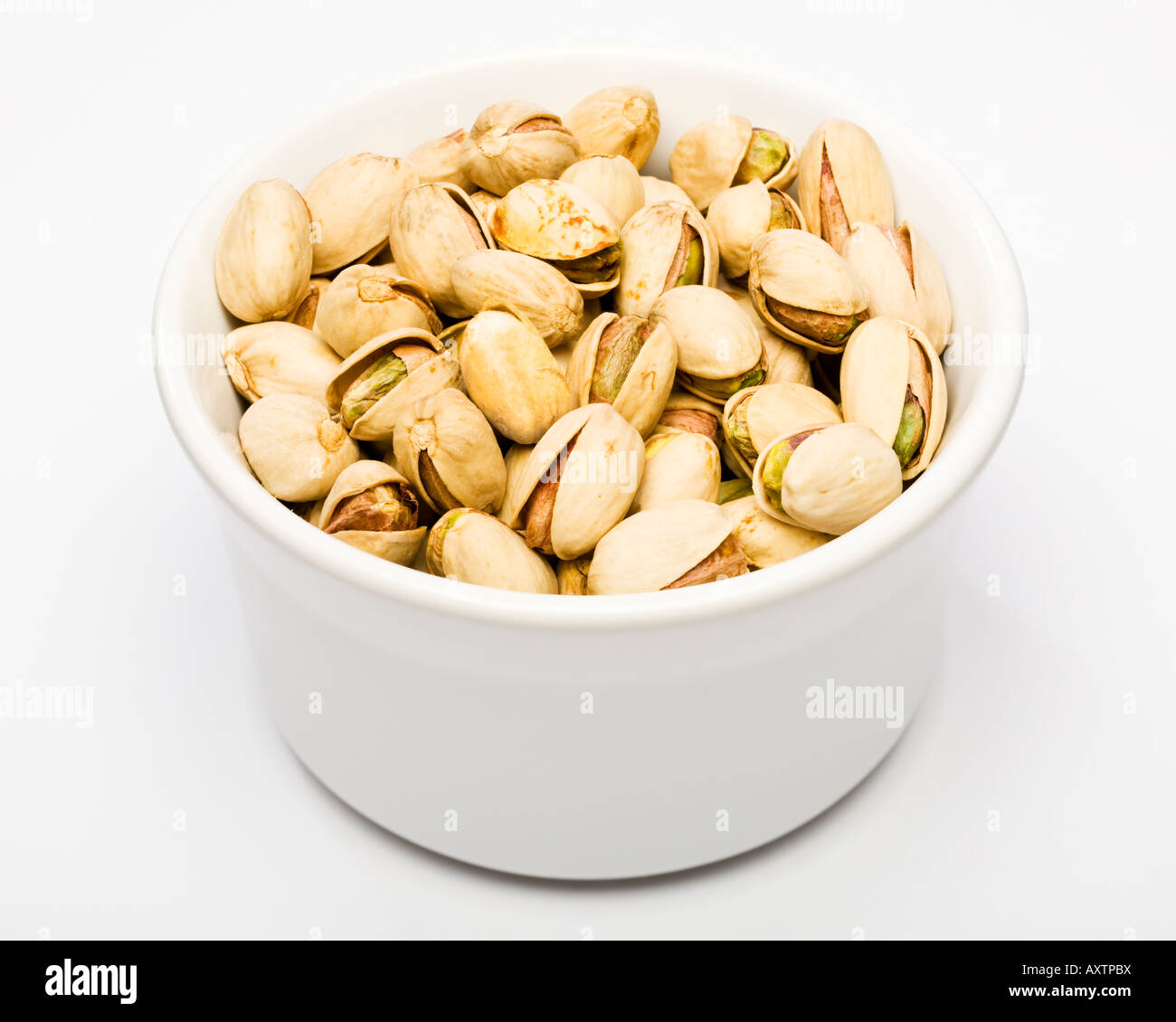 Pistachio nuts in a white bowl Stock Photo