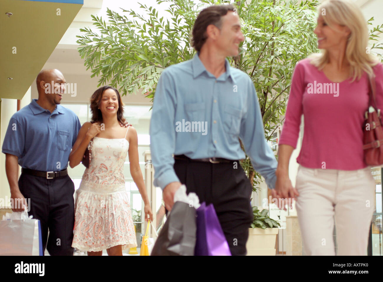 Two young couples carrying shopping bags Stock Photo