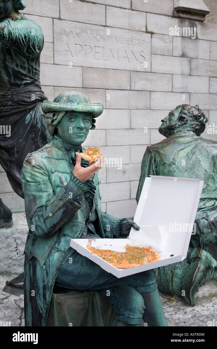 Human Statue eating a pizza outside the Cathedral of Our Lady, Antwerp. Belgium Stock Photo