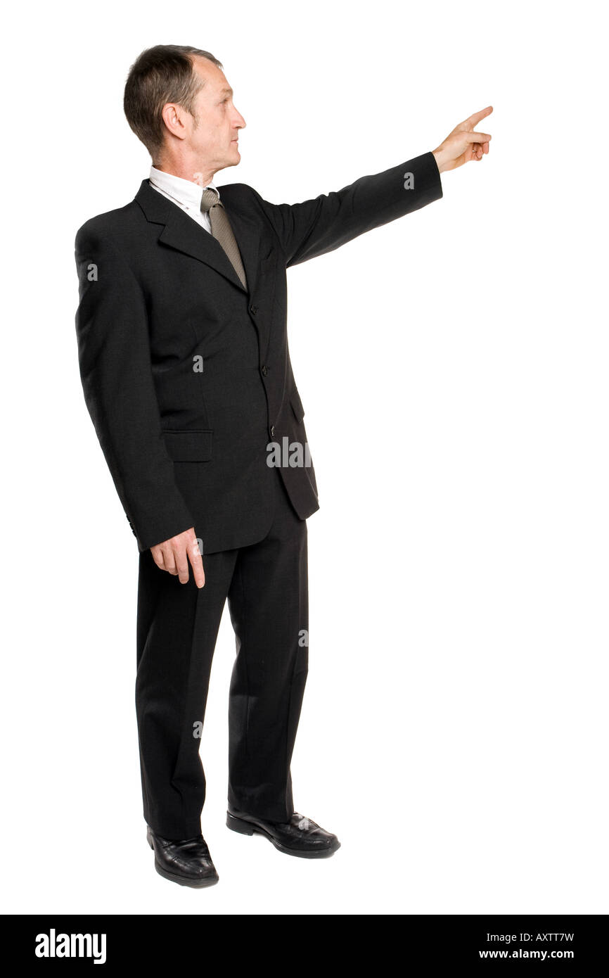 Business man standing in a black suit showing the right direction with his finger. Background is pure white. Stock Photo