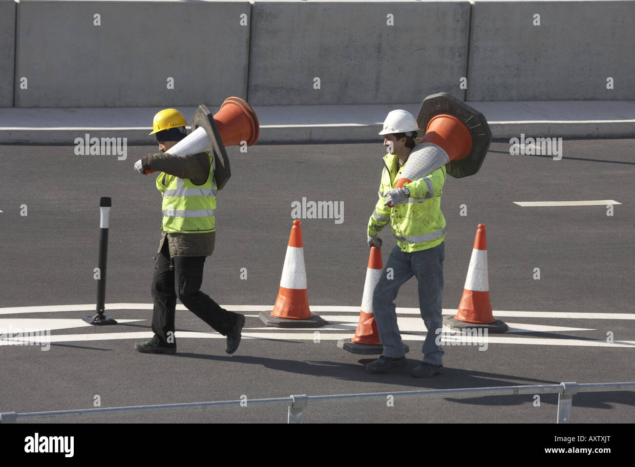 Construction workers carry cones in car parking area of newly opened
